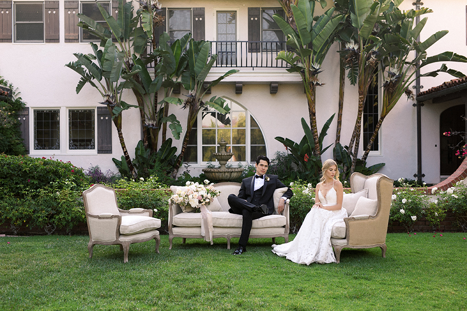  bride in a white flowing gown with a full skirt and the groom in a black tuxedo