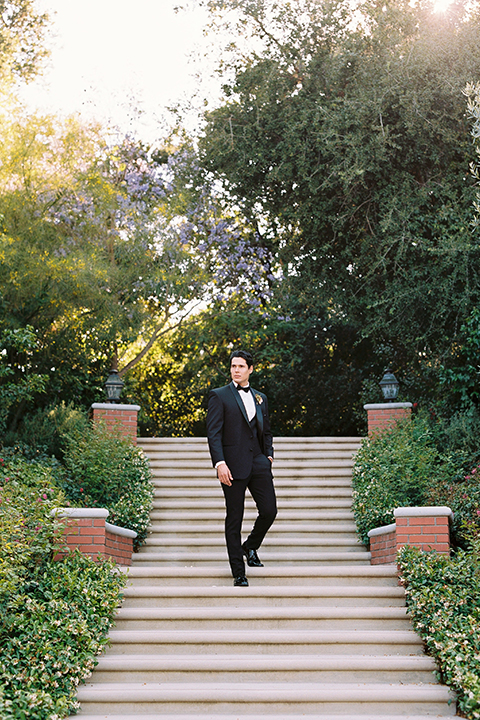  bride in a white flowing gown with a full skirt and the groom in a black tuxedo  