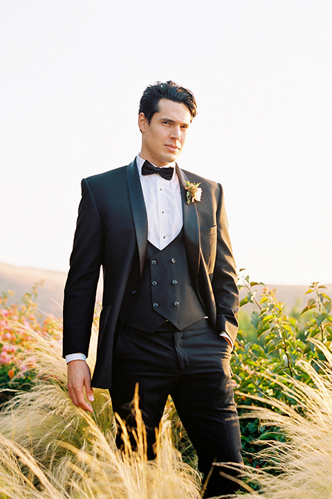  bride in a white flowing gown with a full skirt and the groom in a black tuxedo  