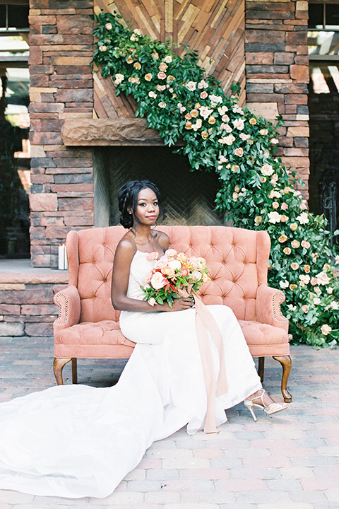  red rocks caramel wedding couple sitting – bride in a strapless modern gown and the groom in a caramel tan suit with a chocolate brown tie 