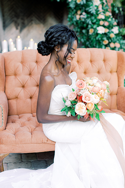  red rocks caramel wedding couple sitting – bride in a strapless modern gown and the groom in a caramel tan suit with a chocolate brown tie