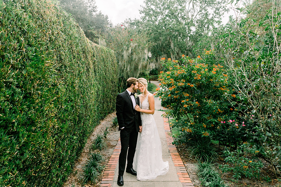  bride in a flowing gown with an off the shoulder detail and the groom in a black tuxedo 