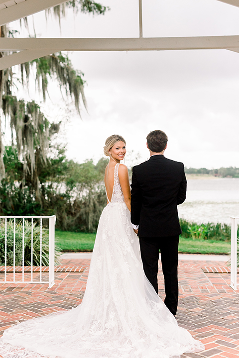  bride in a flowing gown with an off the shoulder detail and the groom in a black tuxedo 