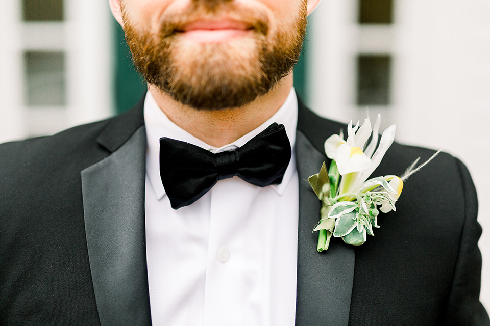  bride in a flowing gown with an off the shoulder detail and the groom in a black tuxedo 