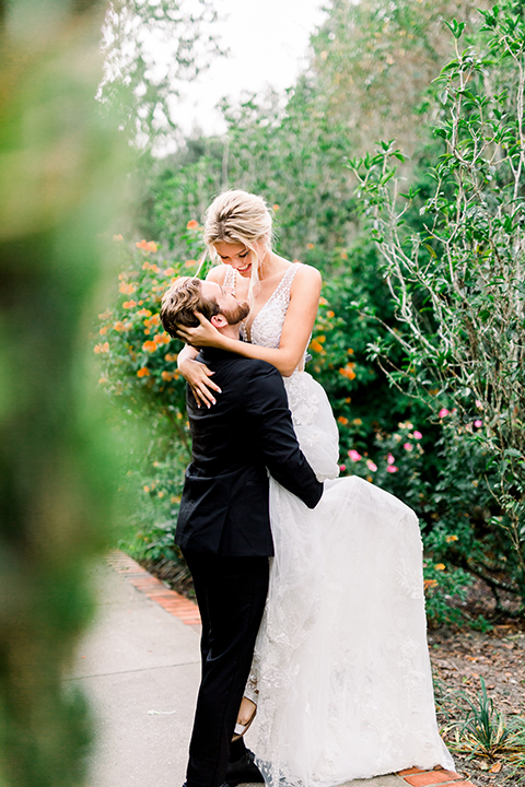  bride in a flowing gown with an off the shoulder detail and the groom in a black tuxedo 