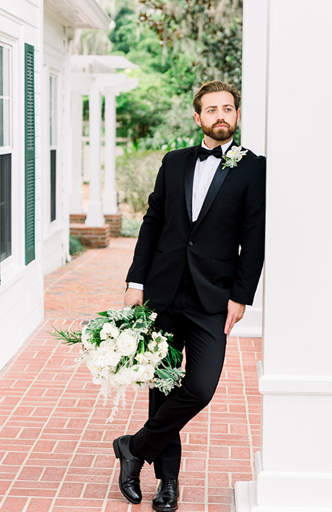  bride in a flowing gown with an off the shoulder detail and the groom in a black tuxedo 