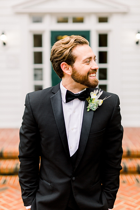  bride in a flowing gown with an off the shoulder detail and the groom in a black tuxedo