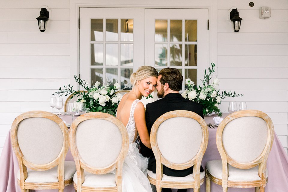  bride in a flowing gown with an off the shoulder detail and the groom in a black tuxedo 