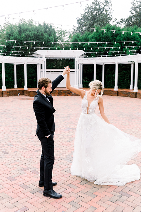  bride in a flowing gown with an off the shoulder detail and the groom in a black tuxedo