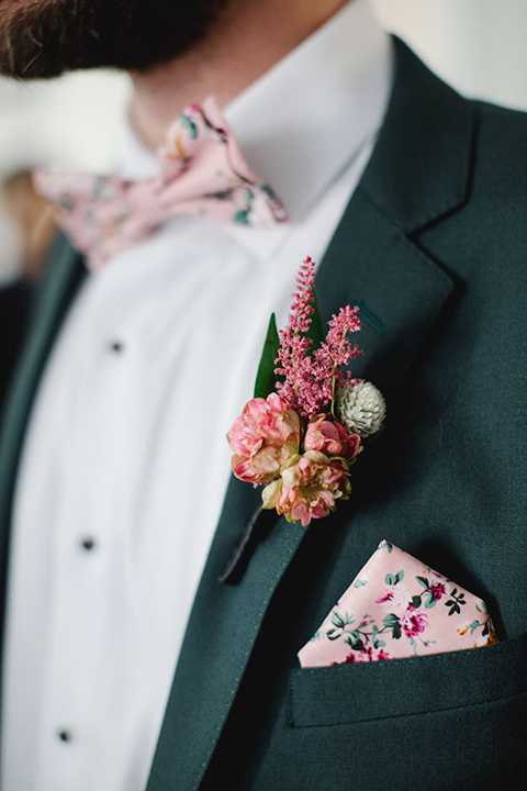  groom in a green suit with a pink floral bow tie 