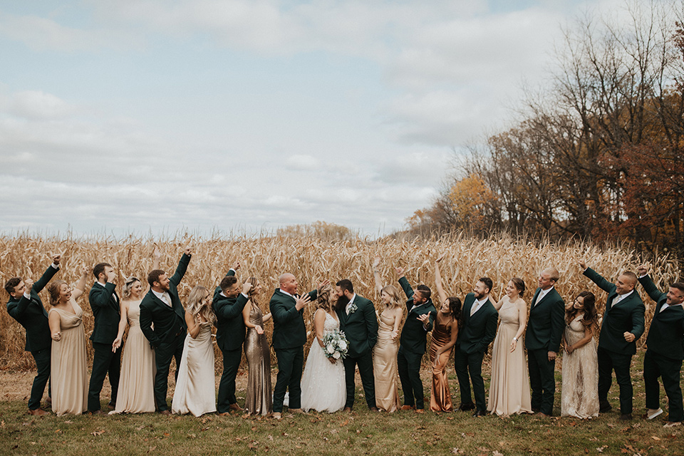  bride in a modern boho gown and the groom and groomsmen in green suits and the bridesmaids in blush gowns 