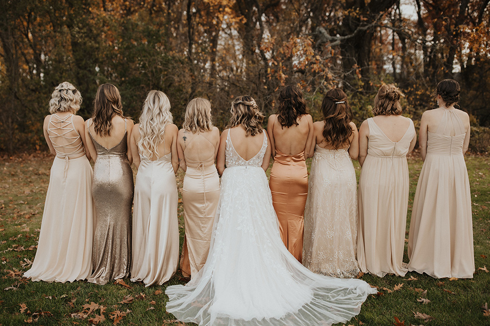  bride in a modern boho gown and the groom and groomsmen in green suits and the bridesmaids in blush gowns 