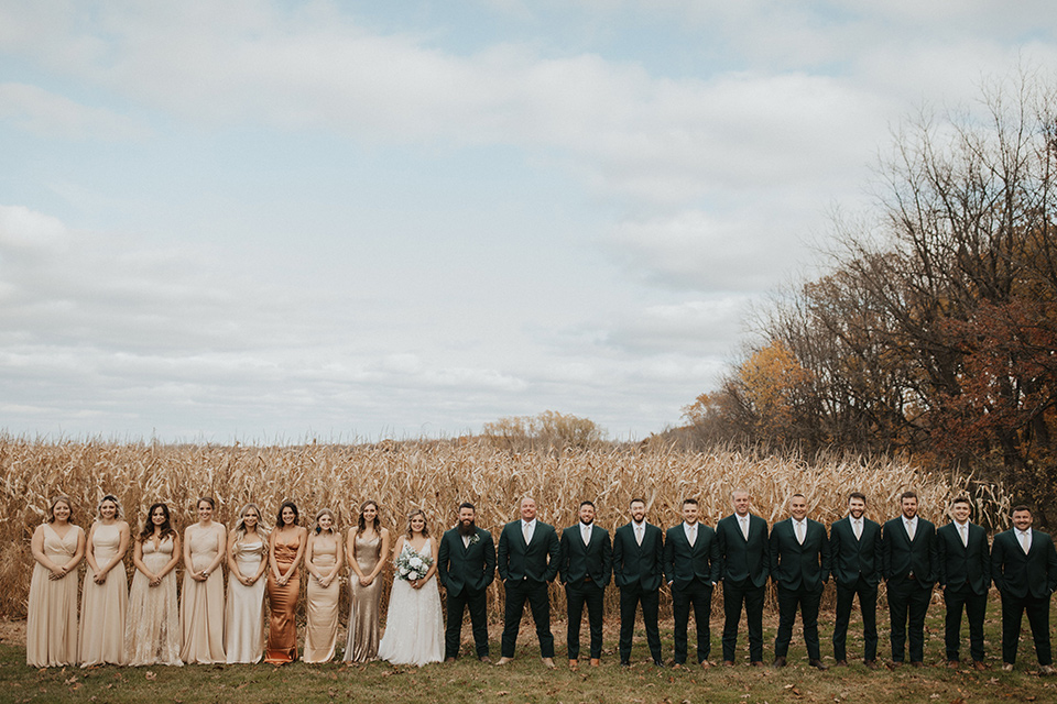  bride in a modern boho gown and the groom and groomsmen in green suits and the bridesmaids in blush gowns 