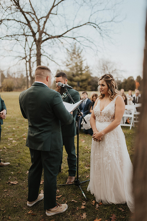  bride in a modern boho gown and the groom and groomsmen in green suits and the bridesmaids in blush gowns 