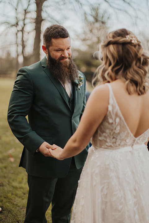  bride in a modern boho gown and the groom and groomsmen in green suits and the bridesmaids in blush gowns 