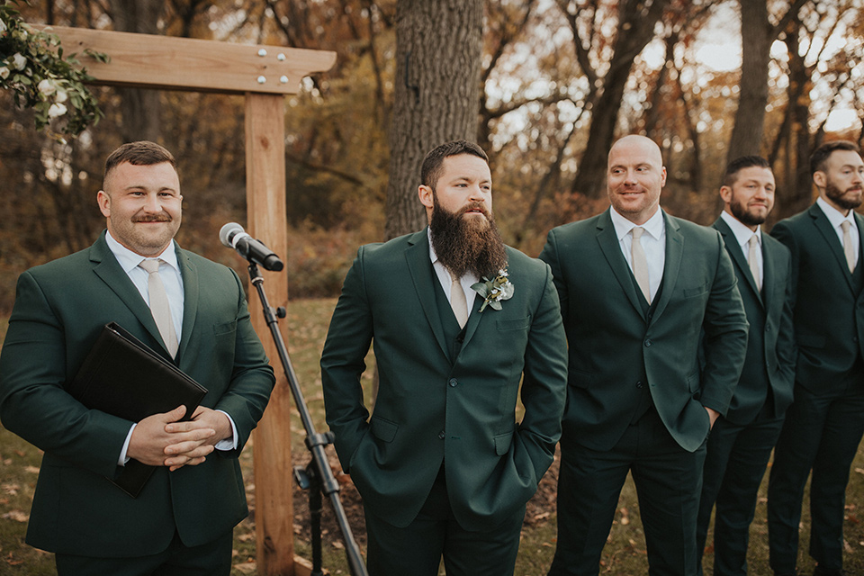  bride in a modern boho gown and the groom and groomsmen in green suits and the bridesmaids in blush gowns 