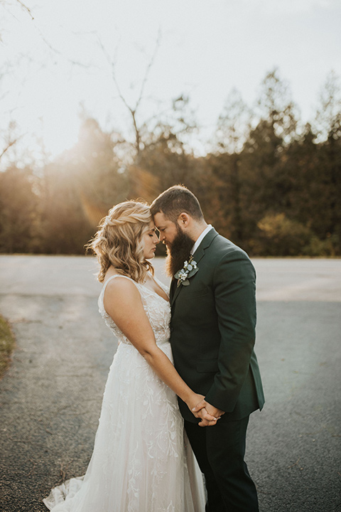  bride in a modern boho gown and the groom and groomsmen in green suits and the bridesmaids in blush gowns 