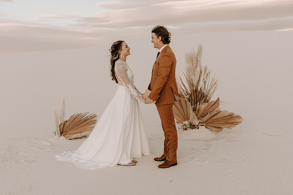  a national park elopement with the groom in a caramel brown suit and the bride in a lace gown 