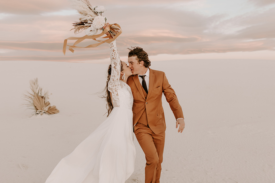  a national park elopement with the groom in a caramel brown suit and the bride in a lace gown 