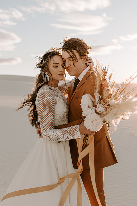  a national park elopement with the groom in a caramel brown suit and the bride in a lace gown 