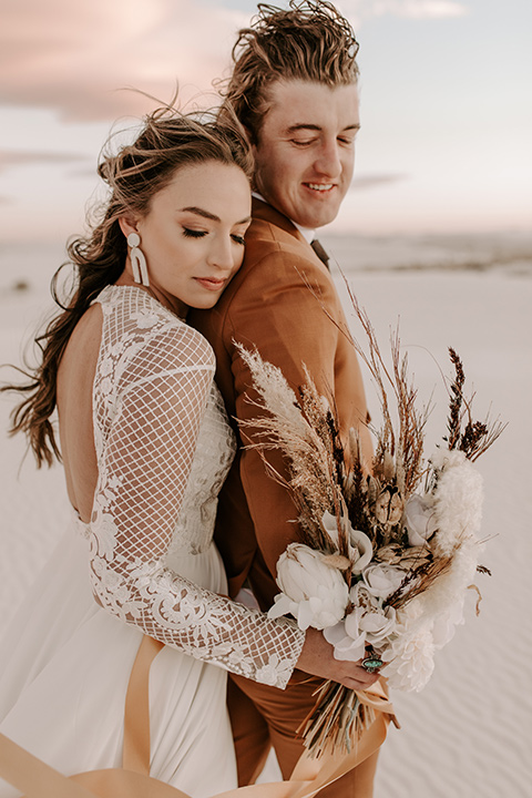  a national park elopement with the groom in a caramel brown suit and the bride in a lace gown 