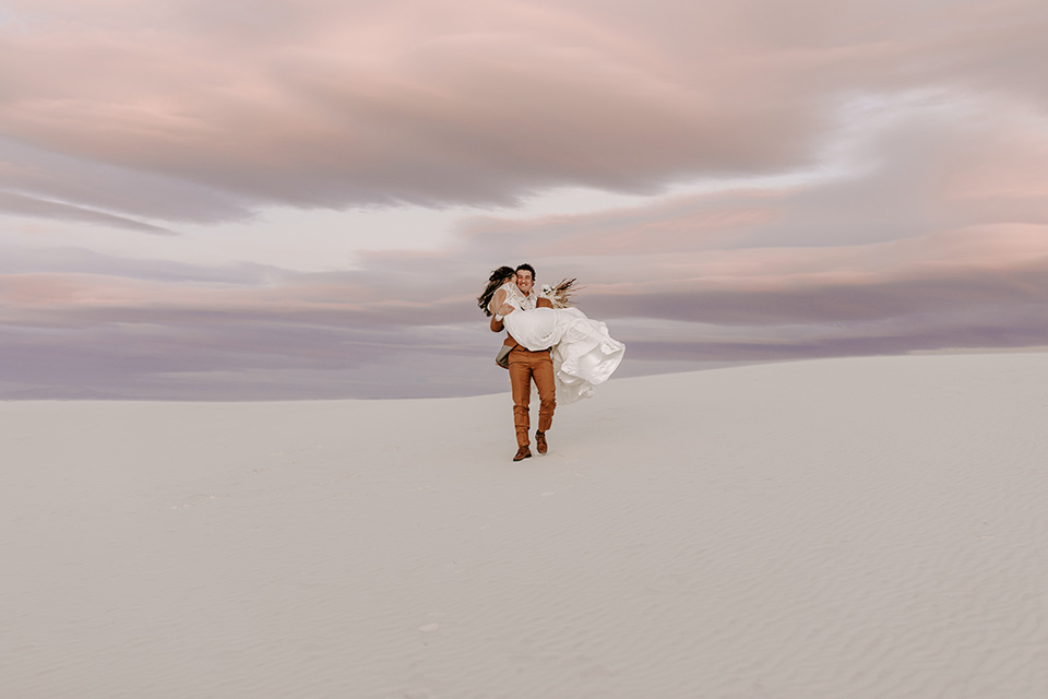  a national park elopement with the groom in a caramel brown suit and the bride in a lace gown 