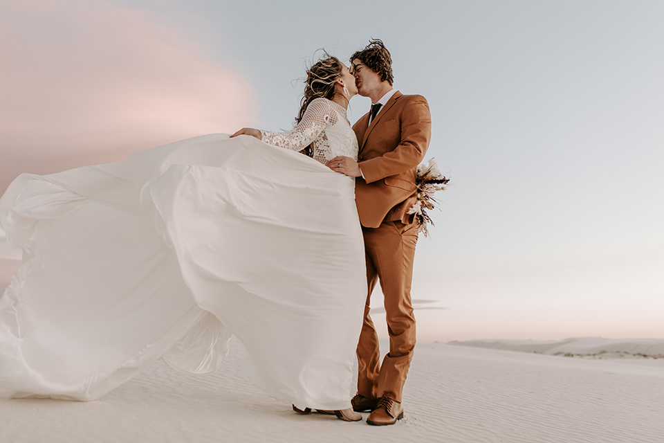  a national park elopement with the groom in a caramel brown suit and the bride in a lace gown 