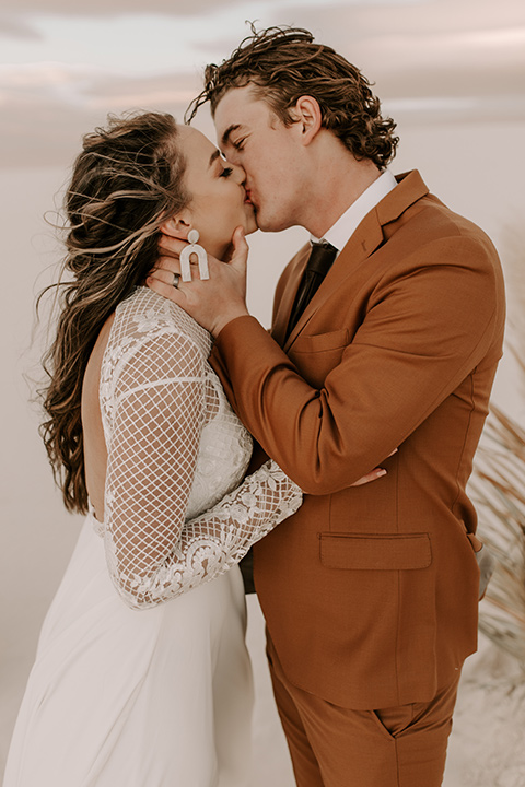  a national park elopement with the groom in a caramel brown suit and the bride in a lace gown 