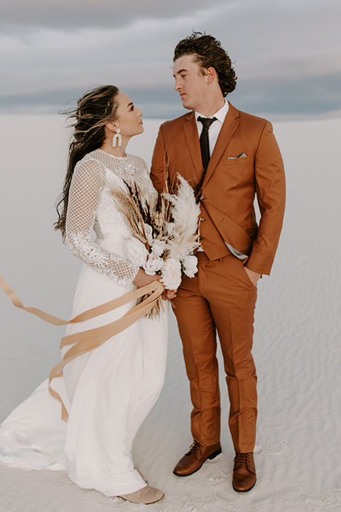  a national park elopement with the groom in a caramel brown suit and the bride in a lace gown 