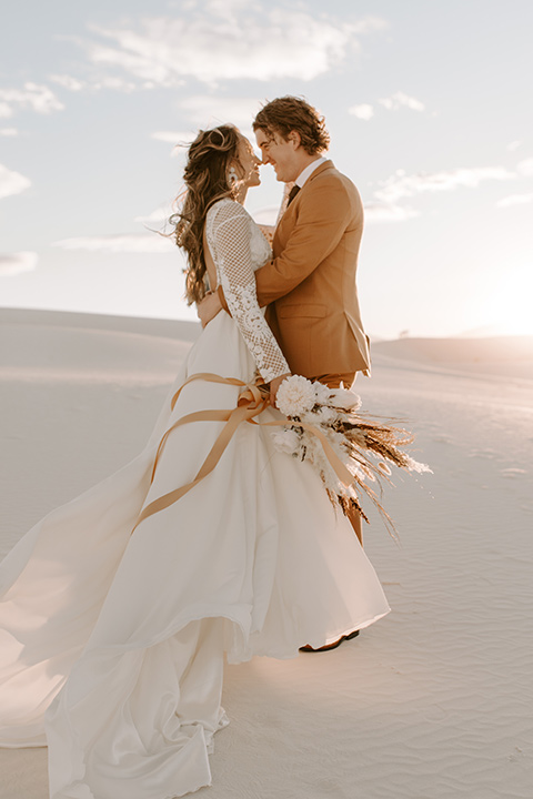  a national park elopement with the groom in a caramel brown suit and the bride in a lace gown 