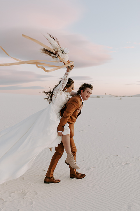  a national park elopement with the groom in a caramel brown suit and the bride in a lace gown 