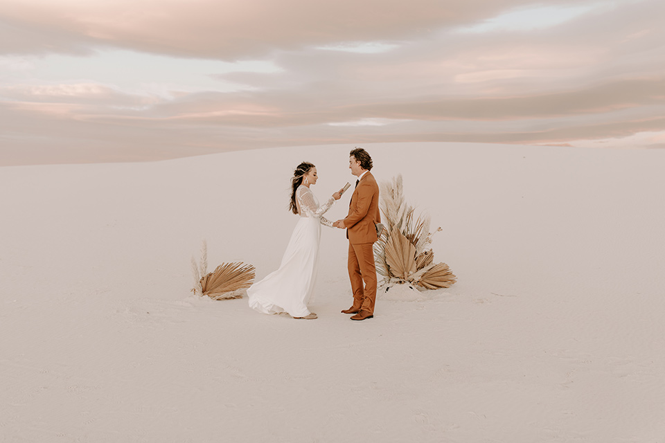  a national park elopement with the groom in a caramel brown suit and the bride in a lace gown 