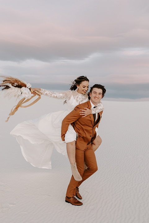  a national park elopement with the groom in a caramel brown suit and the bride in a lace gown 
