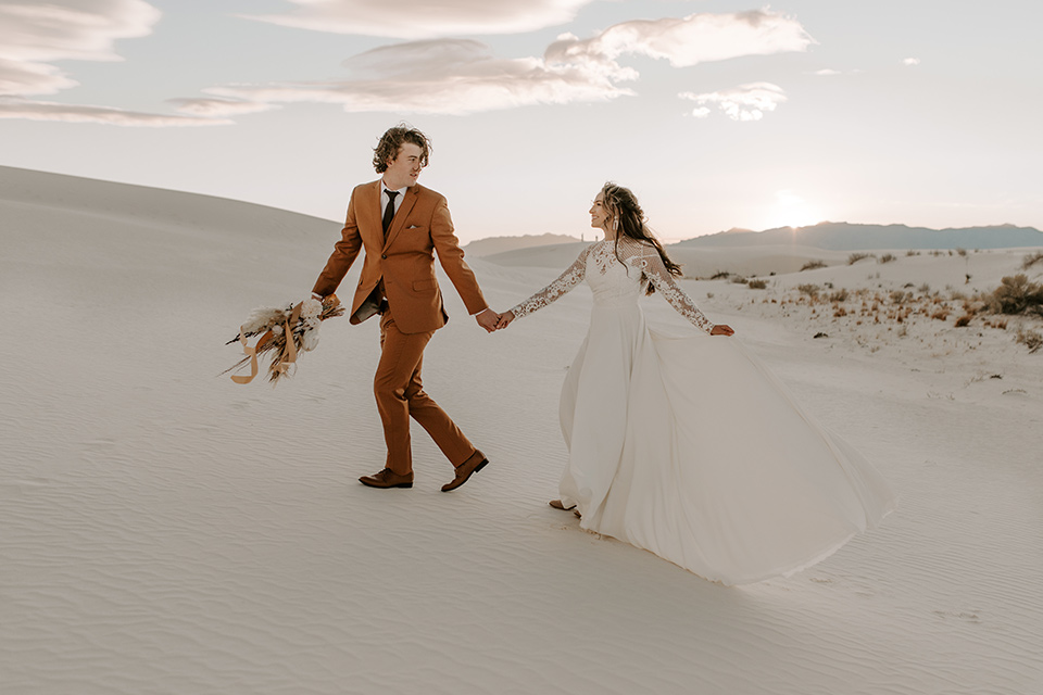  a national park elopement with the groom in a caramel brown suit and the bride in a lace gown 