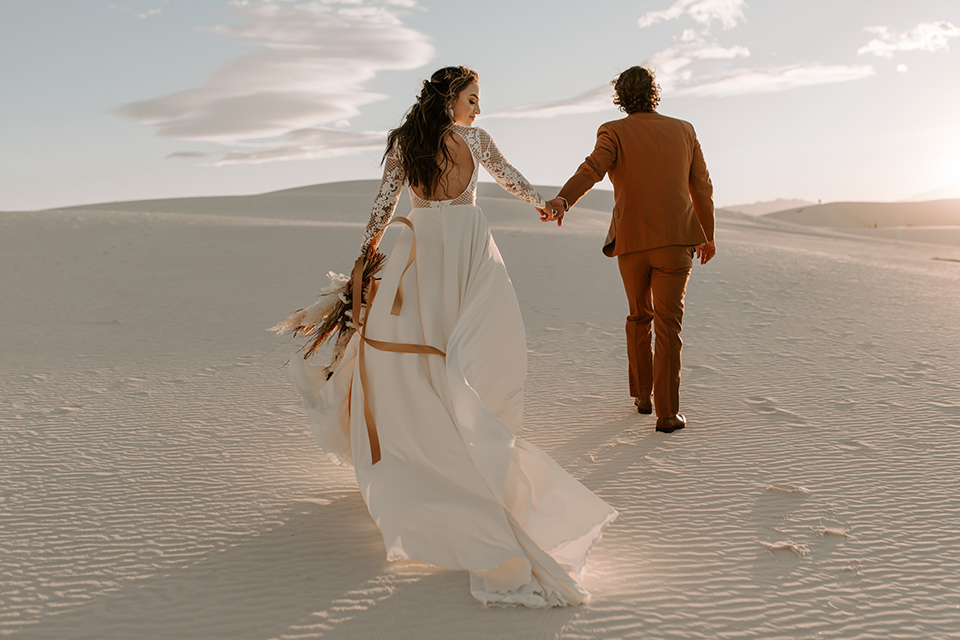  a national park elopement with the groom in a caramel brown suit and the bride in a lace gown 