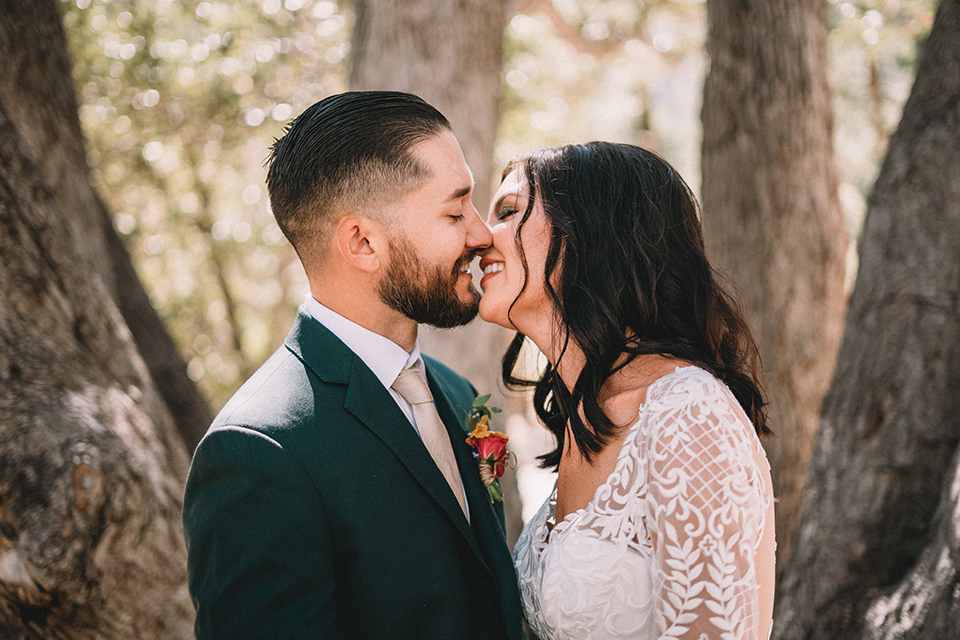  camp wrightwood wedding with the groom in a green suit and floral tie and the bride in a ballgown with lace sleeves 