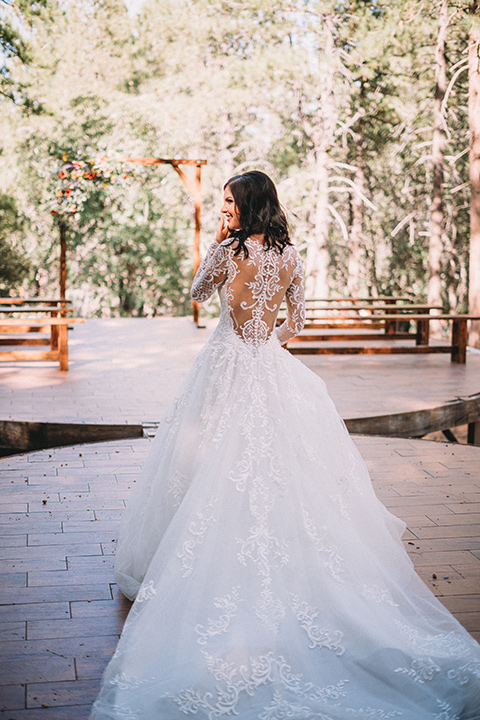  camp wrightwood wedding with the groom in a green suit and floral tie and the bride in a ballgown with lace sleeves 