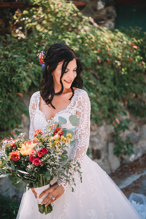  camp wrightwood wedding with the groom in a green suit and floral tie and the bride in a ballgown with lace sleeves 