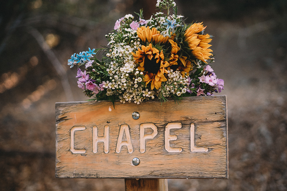  camp wrightwood wedding with the groom in a green suit and floral tie and the bride in a ballgown with lace sleeves 