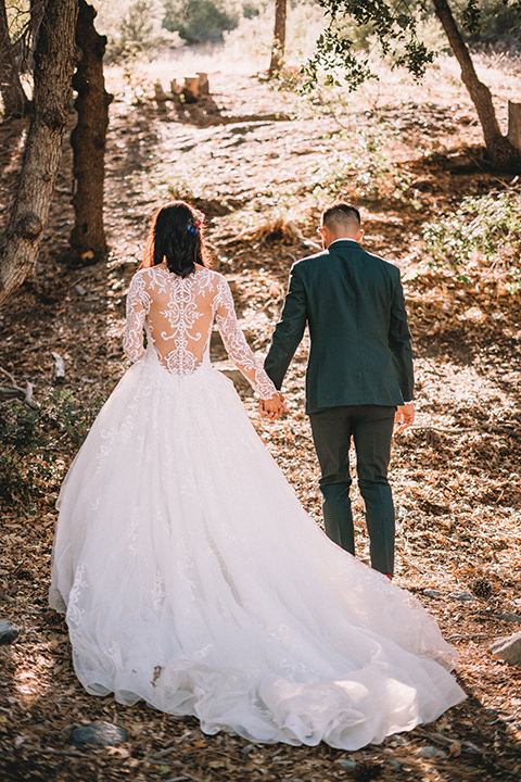  camp wrightwood wedding with the groom in a green suit and floral tie and the bride in a ballgown with lace sleeves 