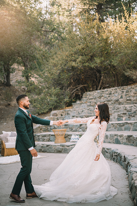  camp wrightwood wedding with the groom in a green suit and floral tie and the bride in a ballgown with lace sleeves 