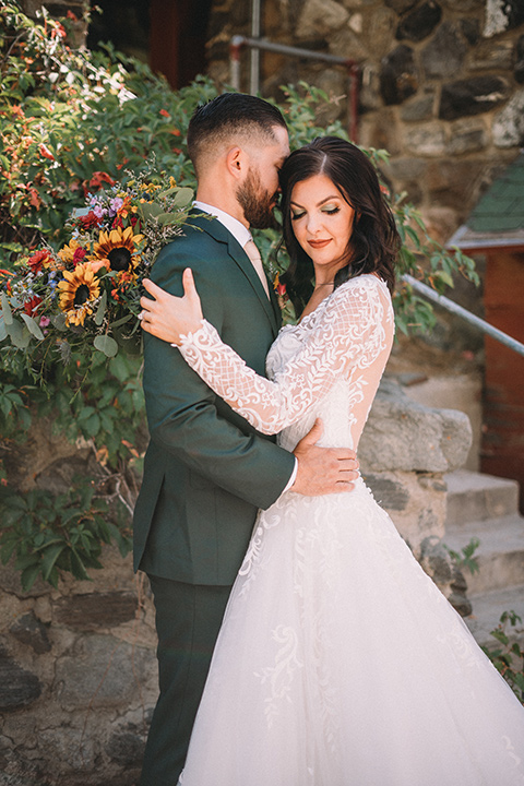  camp wrightwood wedding with the groom in a green suit and floral tie and the bride in a ballgown with lace sleeves 