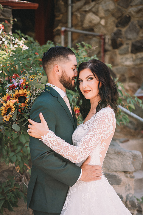  camp wrightwood wedding with the groom in a green suit and floral tie and the bride in a ballgown with lace sleeves 