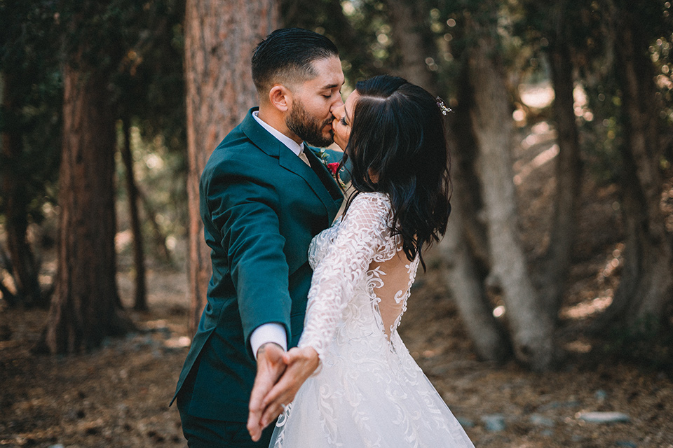  camp wrightwood wedding with the groom in a green suit and floral tie and the bride in a ballgown with lace sleeves 