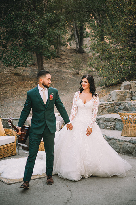  camp wrightwood wedding with the groom in a green suit and floral tie and the bride in a ballgown with lace sleeves 