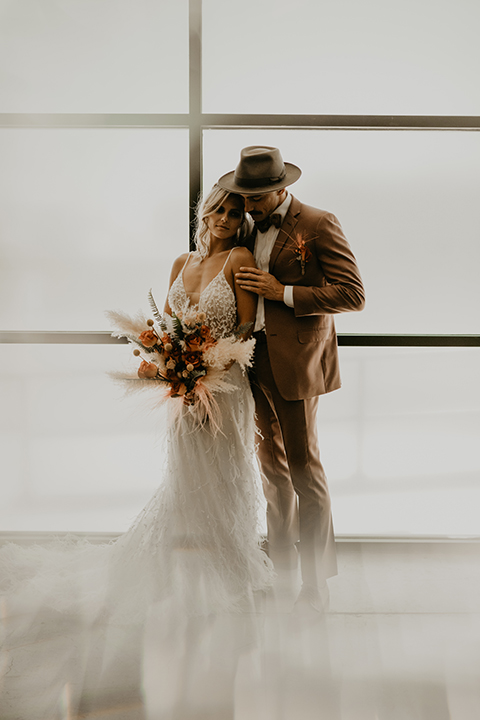  wedding at the colony house with bohemian touches and the groom in a rose pink suit and wide brimmed hat