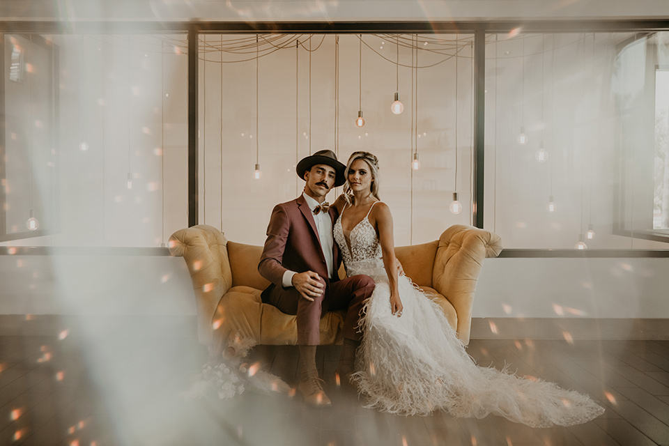  wedding at the colony house with bohemian touches and the groom in a rose pink suit and wide brimmed hat 