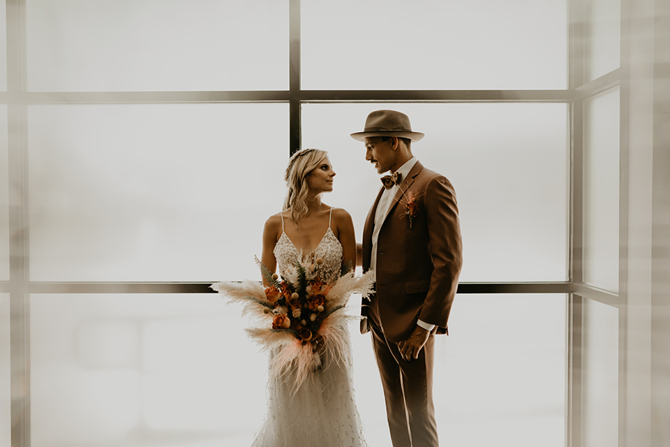  wedding at the colony house with bohemian touches and the groom in a rose pink suit and wide brimmed hat 