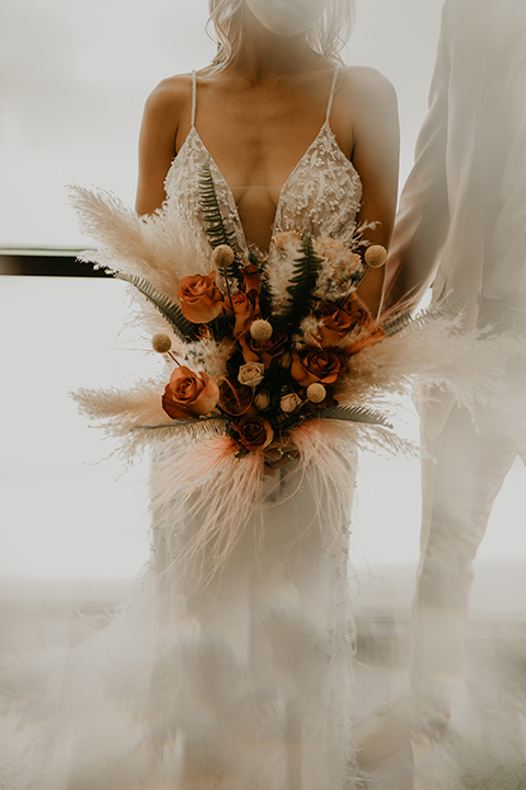  wedding at the colony house with bohemian touches and the groom in a rose pink suit and wide brimmed hat 