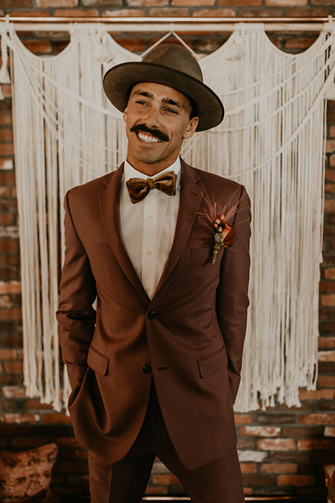  wedding at the colony house with bohemian touches and the groom in a rose pink suit and wide brimmed hat